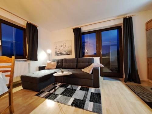 a living room with a couch and a table at Apartment Helga by Interhome in Fieberbrunn