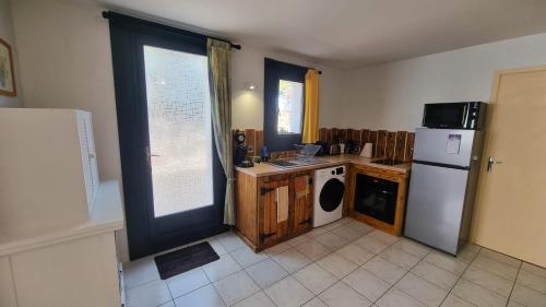 une cuisine avec un réfrigérateur et un lave-vaisselle dans l'établissement Appartement T3 avec extérieur, à Fitou