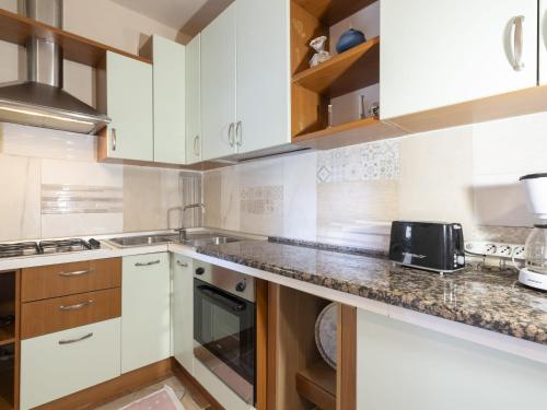Una cocina con gabinetes blancos y encimera. en Apartment Fulvia by Interhome, en Santo Stefano al Mare