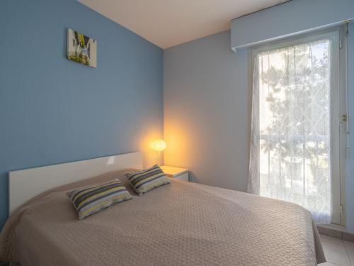 - une chambre avec un lit avec deux oreillers et une fenêtre dans l'établissement Apartment La Plage by Interhome, à Pontaillac