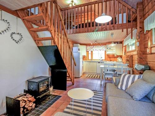 ein Wohnzimmer mit Couch und Ofen in der Unterkunft Holiday Home Marjatan mökki by Interhome in Ylikyro