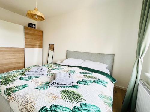 a bedroom with a bed with a green and white comforter at Twenty Five Apartment in Heidenau