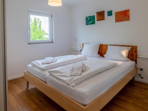 um quarto com uma cama com lençóis brancos e uma janela em Holiday Home Sophia by Interhome em Dittishausen
