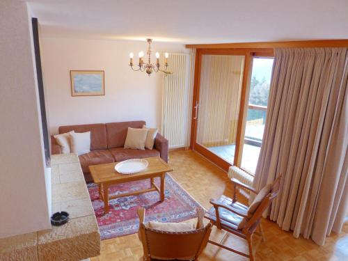 ein Wohnzimmer mit einem Sofa und einem Tisch in der Unterkunft Apartment Les Mischabels-2 by Interhome in Crans-Montana