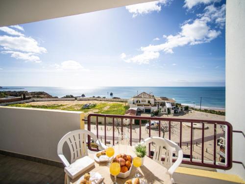 un tavolo e sedie su un balcone con vista sull'oceano di Apartment Torre da Rocha by Interhome a Portimão