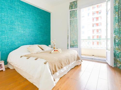 - une chambre dotée d'un lit avec un mur bleu dans l'établissement Apartment Les Yuccas Promenade des Anglais by Interhome, à Nice