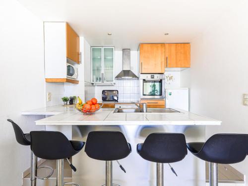 une cuisine avec des chaises noires et un comptoir blanc dans l'établissement Apartment Les Yuccas Promenade des Anglais by Interhome, à Nice