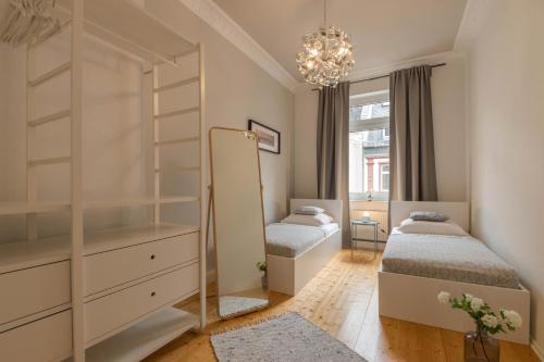 1 dormitorio con 2 camas individuales y espejo en Business Apartment, en Wiesbaden