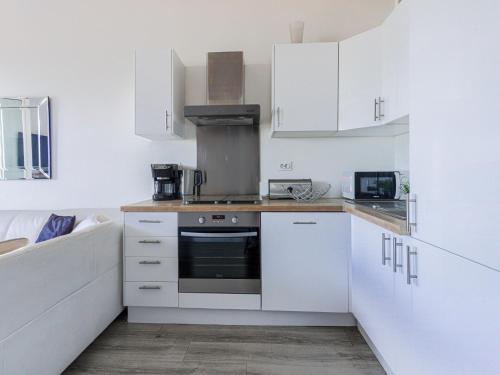 a kitchen with white cabinets and a stove at Studio La Joconde by Interhome in Nice