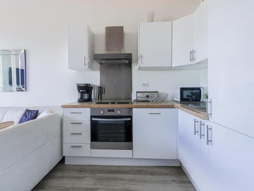 une cuisine avec des armoires blanches et une cuisinière dans l'établissement Studio La Joconde by Interhome, à Nice