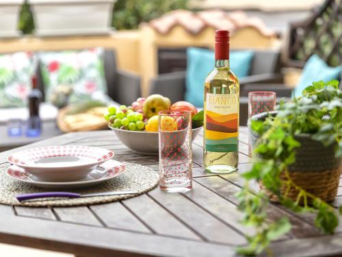 una botella de vino y un bol de fruta en una mesa en Apartment D3 - 6 by Interhome, en Marinella