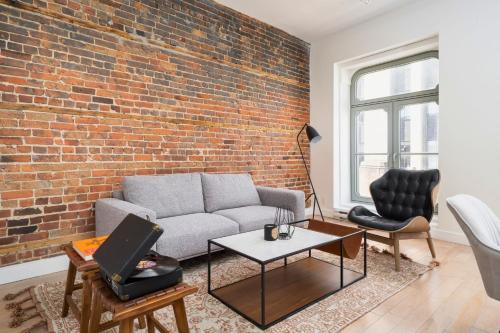 ein Wohnzimmer mit Sofa und Ziegelwand in der Unterkunft Le Merrill Boutique Hotel in Montreal