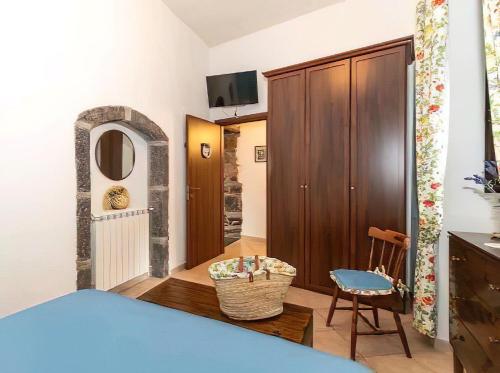 a bedroom with a bed and a cabinet and a chair at Casa Vacanza La Fontanella in Piedimonte Etneo