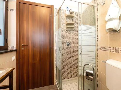 y baño con ducha y puerta de cristal. en Casa Vacanza La Fontanella, en Piedimonte Etneo