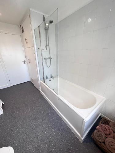 e bagno con doccia, lavandino e vasca. di Jasper Apartment a Lyme Regis