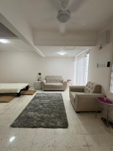 a living room with two couches and a rug at Dagang Homestay in Ampang