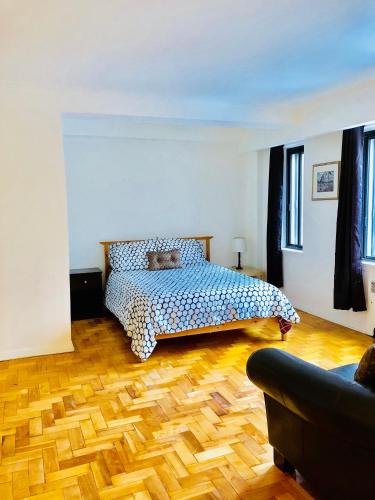 - une chambre avec un lit et du parquet dans l'établissement Stylish Montreal Apartment: Comfortable Stay in the Golden Square Mile, à Montréal