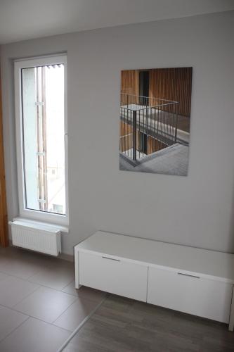 a white room with a white dresser and a mirror at Lakepark Residence in Staré Splavy