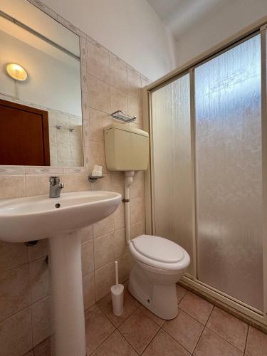 a bathroom with a toilet and a sink and a shower at Hotel Caruso in Rimini