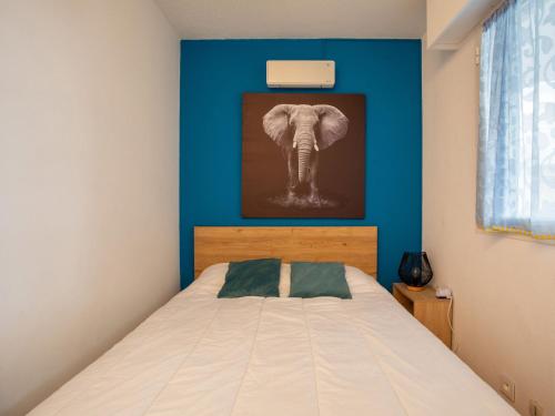 - une chambre avec un lit orné d'une peinture d'éléphant dans l'établissement Studio Le Royal Park by Interhome, à Villeneuve-Loubet