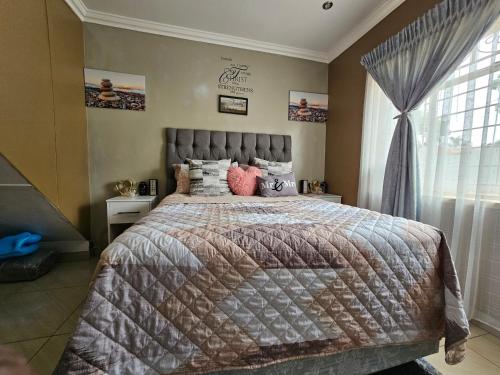 a bedroom with a large bed and a window at Downham Views in Johannesburg