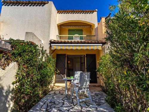 une terrasse avec deux chaises devant une maison dans l'établissement Studio Les Mas de Pramousquier-12 by Interhome, au Lavandou
