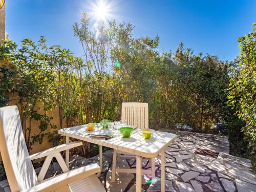 einen Tisch und zwei Stühle auf einer Terrasse in der Unterkunft Studio Les Mas de Pramousquier-12 by Interhome in Le Lavandou