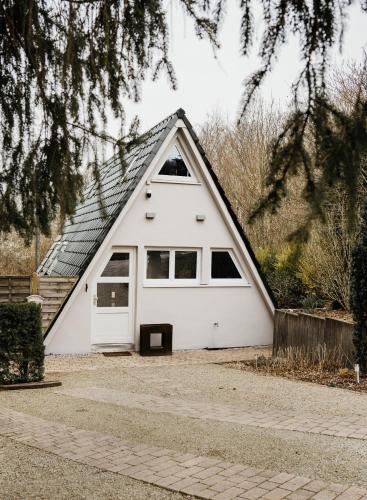 a white garage with a pitched roof at Naturhaus am Felsenweg in Mitlosheim