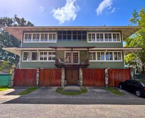 ein grünes Haus mit einem roten Zaun davor in der Unterkunft Casa Randa in Panama-Stadt