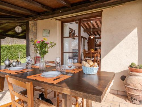 une salle à manger avec une table en bois, des assiettes et des verres dans l'établissement Holiday Home Elena by Interhome, à Sassofortino
