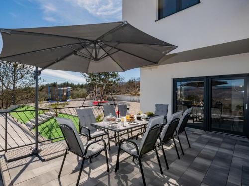 a table with chairs and an umbrella on a patio at Villa Villa Karin by Interhome in Imotski