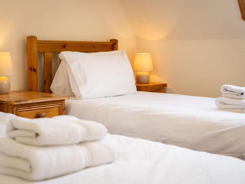 a bedroom with two beds with white towels on them at Holiday Home Lower Curr by Interhome in Skye of Curr