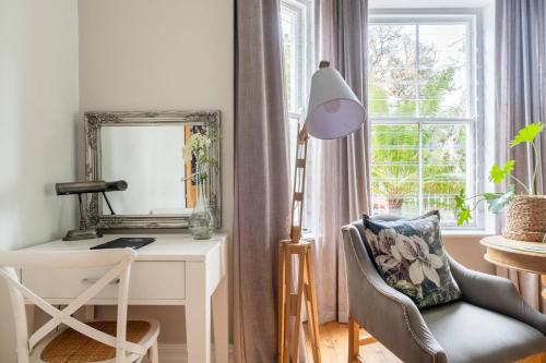 a room with a desk and a chair and a mirror at Bonne Esperance Boutique Guest House in Stellenbosch