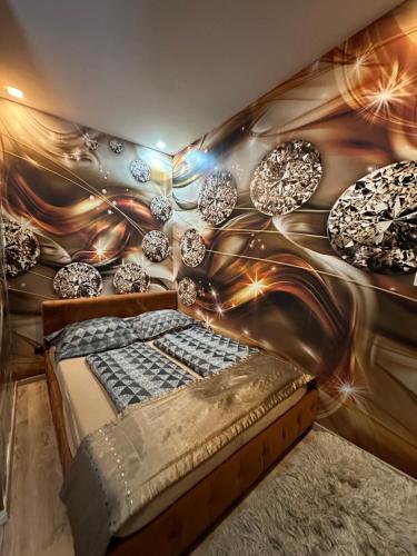 Zimmer mit einem Bett und einer Wand mit Beleuchtung in der Unterkunft Füredi Apartman in Debrecen