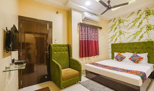 a bedroom with a green bed and a chair at The JK Hotel Nr Railway Station in Nagpur
