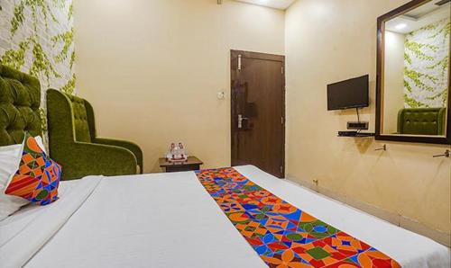a hotel room with a bed and a tv and a room at The JK Hotel Nr Railway Station in Nagpur