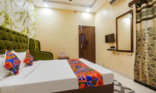 a bedroom with a large bed and a mirror at The JK Hotel Nr Railway Station in Nagpur