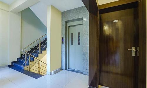 a hallway with a door and stairs in a building at The JK Hotel Nr Railway Station in Nagpur