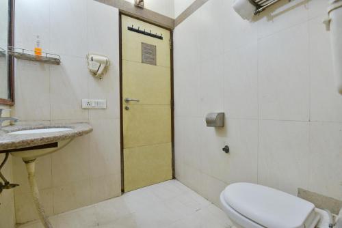 a bathroom with a toilet and a sink at Hotel By Yellow Revels Plum in New Delhi