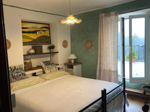 a bedroom with a large bed and a window at Camere e accoglienza LA CASA DELLA NONNA in Borzonasca