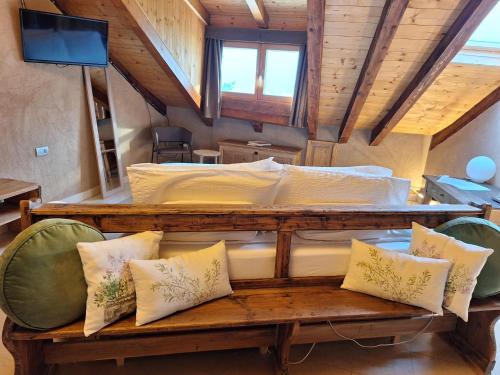 a bedroom with a large bed with pillows on a bench at Vallarom in Avio