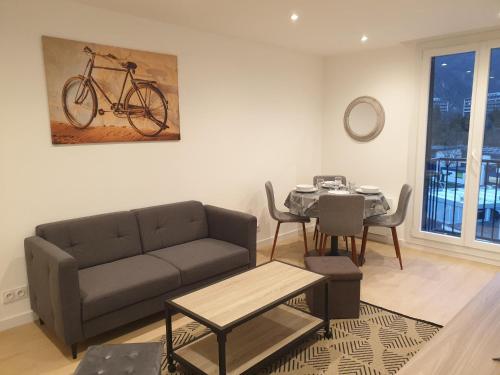 - un salon avec un canapé et une table avec un vélo sur le mur dans l'établissement Appartement 3 Chambres, à Saint-Égrève