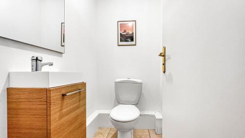 a bathroom with a white toilet and a sink at Coloc Dormant - Hyper-centre, proche transports pour Genève. in Annemasse