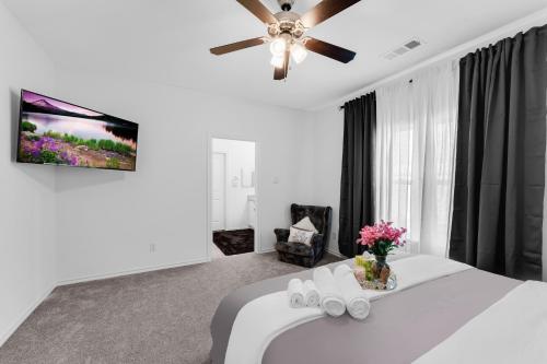 a bedroom with a white bed with a ceiling fan at Grand Prairie Gem Near DFW airport AT&T Stadium in Grand Prairie