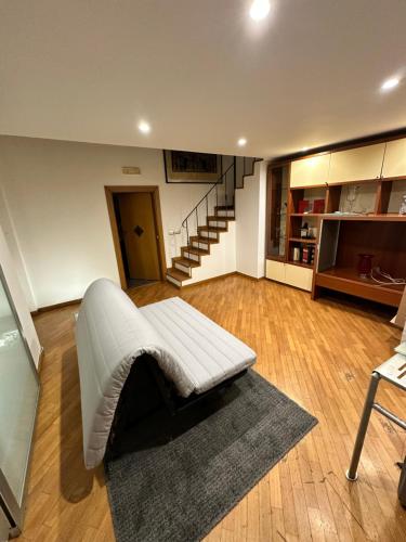 sala de estar con sofá blanco y escalera en La tua casa, en Salerno