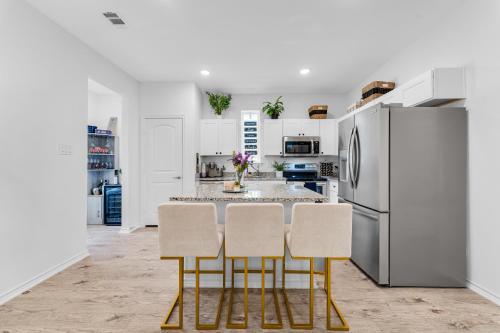 a kitchen with white cabinets and a stainless steel refrigerator at Grand Prairie Gem Near DFW airport AT&T Stadium in Grand Prairie