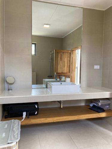 a bathroom with a sink and a large mirror at Villa Trou d'Eau Douce in Trou dʼ Eau Douce