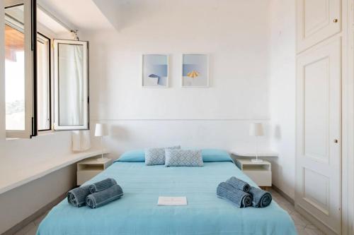 a bedroom with a blue bed with two pillows on it at Villa Stella Turchese - IUN F0243 in Torre delle Stelle
