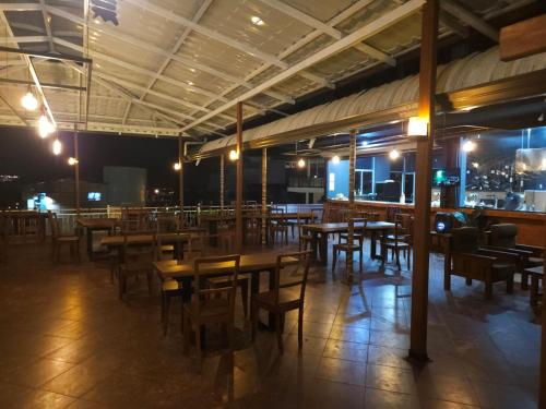 a restaurant with wooden tables and chairs at night at Oyado Marufuku in Kandy