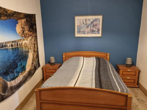 um quarto com uma cama com um quadro na parede em Gîte Les Plantis - Cognac em Cherves-de-Cognac